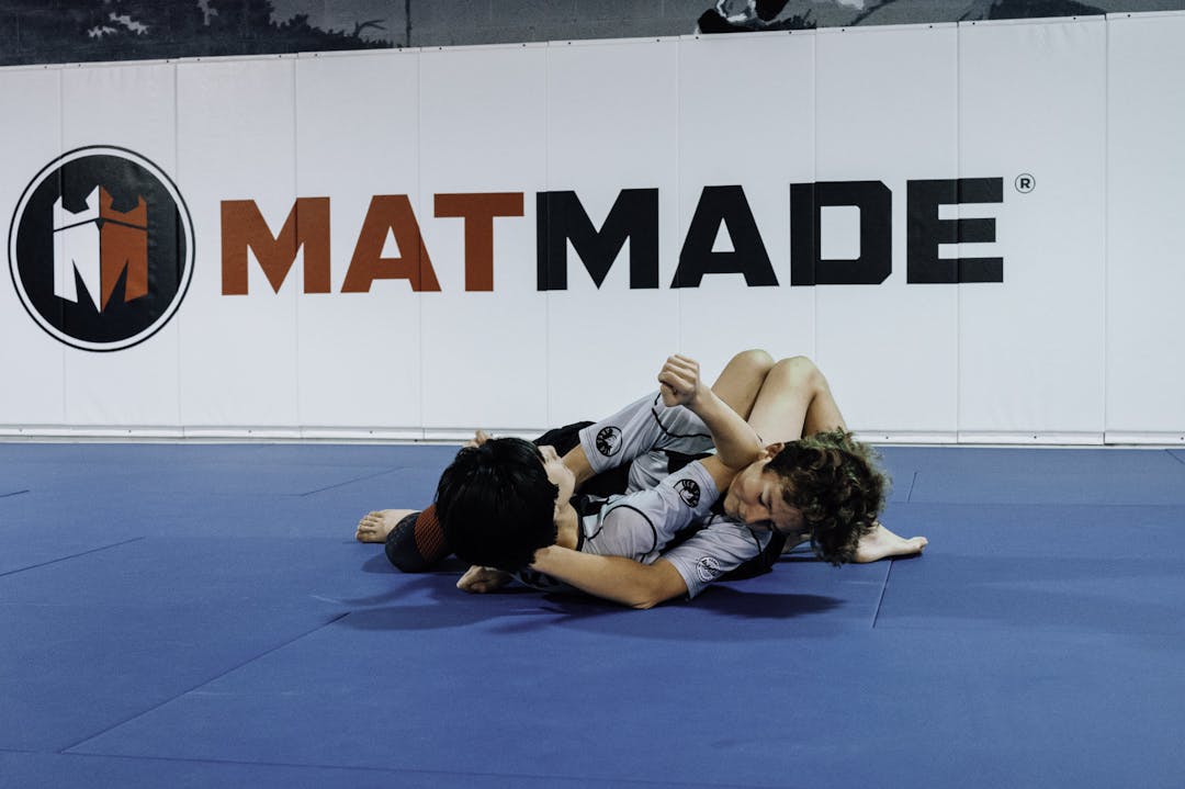 Brazilian Jiu Jitsu Teenagers at Kenny Kim BJJ in Marietta GA rolling on the mats practicing techniques